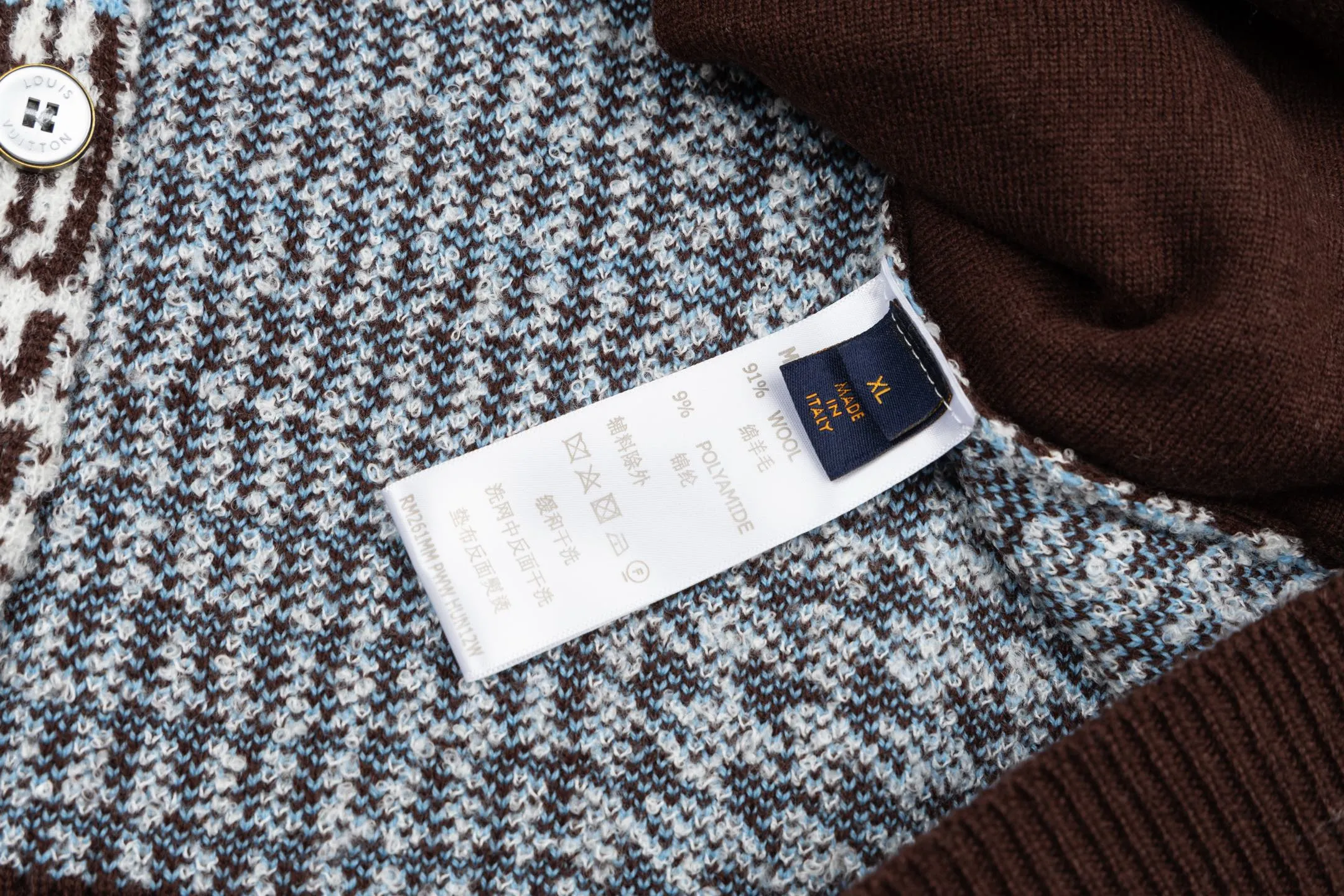🅿️570 1v 26SS houndstooth letter intarsia V-neck knitted cardigan. The original version was purchased for 14,743 and developed. The fabric is made of yarn fabric made of 69% sheep wool blended with 31% nylon. The main pattern is woven with a full-width jacquard process, which interweaves the houndstooth pattern with light blue line texture. At the same time, the brand logo elements are integrated into the body through the intarsia process, and the edges of the pattern are connected delicately and seamlessly. The collar, cuffs and hem are made of 100% sheep wool ribbed fabric, and are edged with double-needle seaming technology, which has both elasticity and shaping effect. The front placket is equipped with natural-textured buttons, and the side seam pockets use invisible stitching technology to blend naturally with the jacquard texture of the body. The overall shape is shaped through three-dimensional tailoring, and the shoulders are stitched with seamless stitching to ensure fit and comfort. The entire piece is finished with handcrafted details in an Italian workshop, showing the craftsmanship precision of high-quality knitted items. The overall wiring is straight and delicate, the fabric is comfortable and soft, and the color is consistent without color difference. It can be matched with the same style to create a fashionable look and control various occasions. Customized accessories, complete with three standards, the same style for men and women. Size:S-M-L-XL